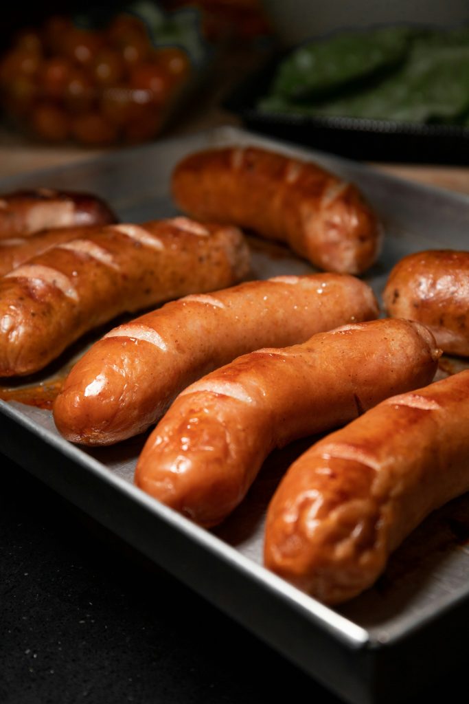 Saucisses Oktoberfest glacées à la Sauce W, pommes et oignons à la bière